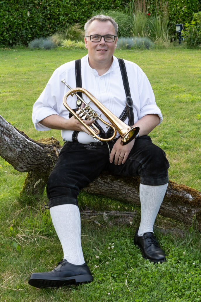 Lid Thomas Van den Broeck in lederhosen en instrument in hand