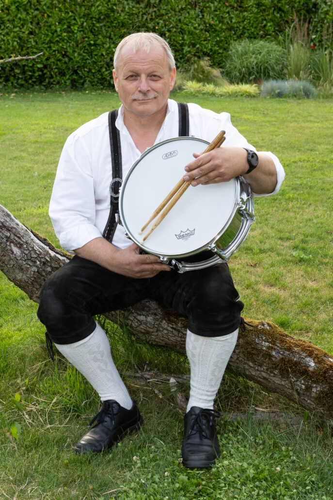 Lid Marco Worm in lederhosen en instrument in hand