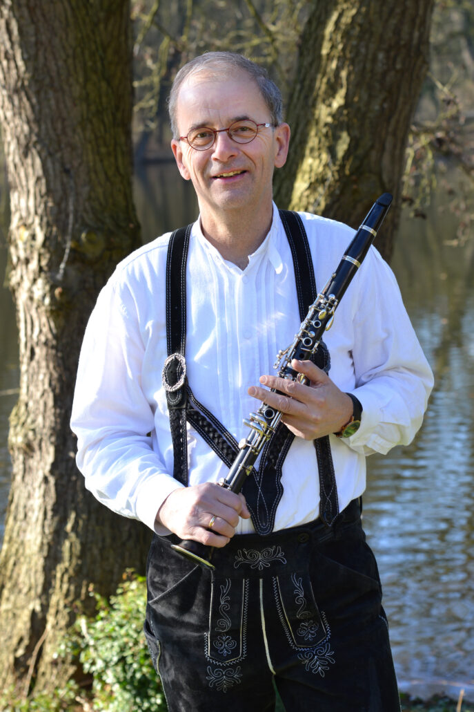 Lid The Driessen in lederhosen en instrument in hand